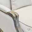 Detailed image of the chair's hand-carved armrest in linen and oak