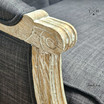 Detailed image of the armchair's armrest, covered in black linen
