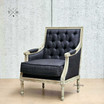 Diagonal front view, emphasizing the chair's elegant black linen fabric and tufted back