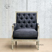 Front perspective of the Pembroke Armchair in black linen, showcasing the tufted back and weathered oak frame