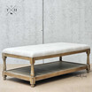 Angle view highlighting the combination of linen upholstery and the sturdy oak frame, illustrating versatility in design on the Parker Coffee Table Ottoman
