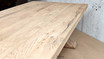 The Charlested Oak Dining Table against a soft, blurred background, focusing on the table's strong presence