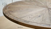 Close-up of the artisan-crafted Darcy Oak Round Table's parquetry and pedestal base, highlighting detail and quality
