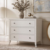 Angled view of the Piastri 3 Drawer Chest in White highlighting its hand-finished paint-stroke patina, elegant carved moulding and antique bronze hardware in a timeless Hamptons-inspired design.