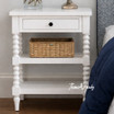 A front view of the Montclair Side Table in White showcasing its bobbin leg detailing and functional drawer and display shelving.