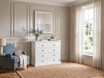 Luxury white drawer chest styled with ceramic vases and fresh foliage.