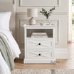 Fremont White Bedside Table featuring two X-pattern drawers and an open top shelf.
