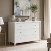 Classic Thomas and Hurley Brynmore 3 drawer chest in white alongside a beige upholstered living room sofa.