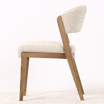 Side profile of the Stanton Dining Chair featuring a gently curved backrest and solid natural wood legs, ideal for modern dining tables.
