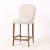 Three quarter front view of the Stratford Kitchen Stool featuring neutral premium woven upholstery, brass stud detailing and natural legs for stylish kitchen seating.