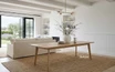 Solid oak dining table with tapered leg in a styled Hamptons-inspired living room setting