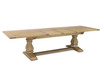 The Sandringham double extension dining table photographed from a front angled view when fully extended, showing its generous proportions and sculptural base.