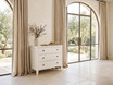 Lando 3 Drawer Chest in white styled beneath large arched windows with linen curtains, featuring decorative books, a ceramic vase and timeless Hamptons-inspired design.