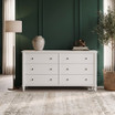 Thomas and Hurley Brynmore 6 Drawer Chest in white styled against a dark green paneled wall.