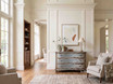 Statement bombe storage chest with three curved drawers and softly distressed finish in a light filled Hamptons-style living room