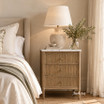 Premium bedside table with marble surface and fluted drawer fronts styled with a lamp and flowers