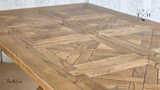 Close-up of the table's top, highlighting the smooth texture and natural oak finish