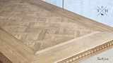 Detailed image of the corner of the Bedford Oak Dining Table, displaying the precision of the parquetry work