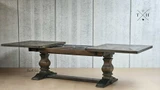 Angled view of the Darcy Oak Table's pedestal base mid-extension, showcasing its support and elegance