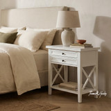 White Hampstead 2 Drawer Bedside Side Table styled with a ceramic lamp and decorative accessories beside a modern upholstered bed, highlighting practical bedside storage.