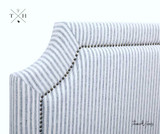 ide view of the headboard, illustrating the depth and profile of the upholstered design and the the embedded stud trim detail surrounding the hamptons headboard