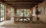 Solid oak dining table with curved bridge-style base, shown in a luxury styled dining space with light coming through the windows