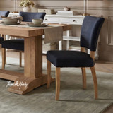 High-end black upholstered dining chair with curved back and natural timber legs by Thomas and Hurley, ideal for Hamptons and contemporary classic interiors.