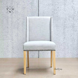 Front view of the Lumley Dining Chair, showcasing its elegant winged back design and sophisticated brass stud detailing.