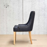 Side view of the Braddock Chair, emphasising its sleek lines and the depth of the tufting detail