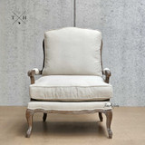 Front perspective of the Cara Occasional Armchair, showcasing natural linen upholstery.
