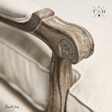 Detailed image of the armchair's armrest and linen fabric