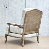 Rear view of the Cara Occasional Armchair,  highlighting the rattan back and weathered oak frame