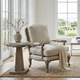 Comfortable upholstered reading chair in weathered oak with French-inspired craftsmanship, in a luxury Hamptons living room