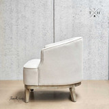 Right side view, displaying the chair's rounded silhouette in natural linen