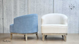 Rear and side view of the two chairs, one in blue chenille and the other in beige cream linen upholstery finish, placed back-to-back. This perspective emphasizes the differences in the upholstery and the weathered oak legs, offering a comprehensive comparison of the finishes.