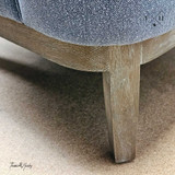 Image focusing on the chair's weathered oak legs.