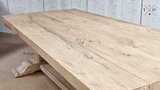The Charlested Oak Dining Table bathed in sunlight, enhancing the rich, natural color of the wood
