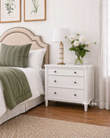 A styled view of a bedside table with storage in white.