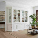 A styled view of the Stonefield Double Display Cabinet Wall Unit with Angled Sides in a living room setting showcasing its angled glass display cabinets with generous display and storage capacity.