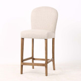 Three quarter front view of the Stratford Kitchen Stool featuring neutral premium woven upholstery, brass stud detailing and natural legs for stylish kitchen seating.