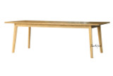 Angled front view of the Lofthouse dining table in natural oak by Thomas & Hurley highlighting elegant tapered legs and contemporary dining table design.