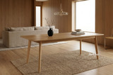 Solid oak timber large 240cm dining table in a styled contemporary interior showcasing tapered leg and oak timber grain