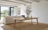 Solid oak dining table with tapered leg in a styled Hamptons-inspired living room setting