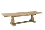 The Sandringham double extension dining table photographed from a front angled view when fully extended, showing its generous proportions and sculptural base.
