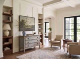 Aged finish three drawer chest with curved profile and traditional metal handles in a styled living room