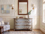 Weathered blue three drawer bombe chest styled in a sophisticated neutral living room