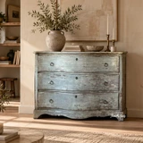 Blue-grey bombe chest of drawers styled with ceramics and natural greenery