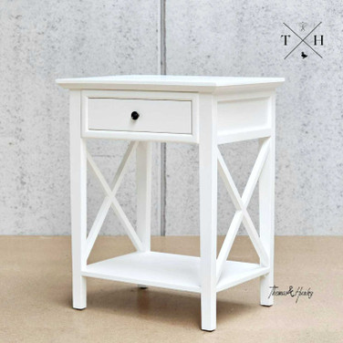 Zoomed-in view focusing on the bedside table's crisp white satin finish