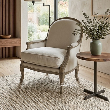Natural linen curved occasional armchair with oak legs styled with a round side table