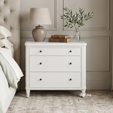 Front view of the Thomas and Hurley Brynmore 3 Drawer Bedside in white next to an upholstered bed.